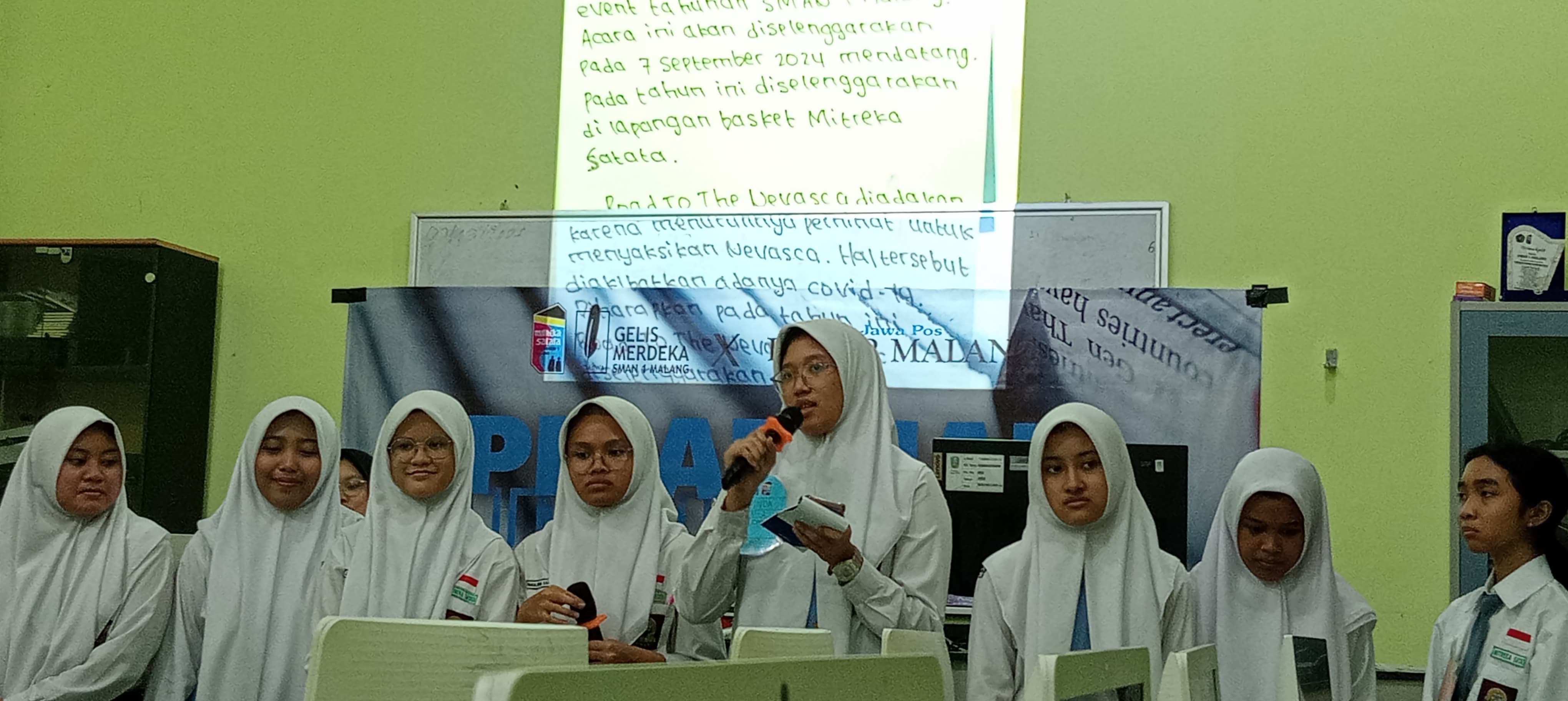 FOKUS : Siswi SMAN 1 Malang Syakira Adinda Putri XI-2 mempresentasikan hasil karya tulisnya bersama rekan satu timnya.