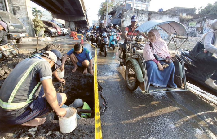 DISELESAIKAN SEHARI: Personel PDAM melakukan perbaikan terhadap pipa di bawah flyover Kotalama, kemarin sore. Total ada 10 personel yang diturunkan ke lokasi.