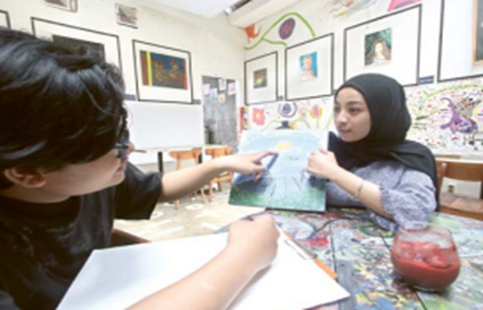 OPSI YANG SUKA SENI: Lintang (kanan) bersama pasangannya menjajal fasilitas melukis bersama di Arthemis Caf&eacute;.