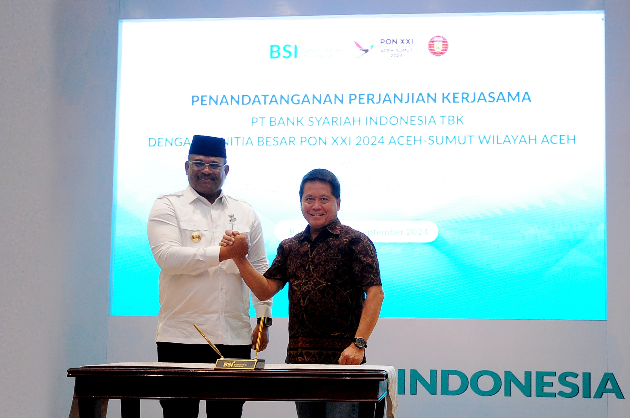 Direktur Utama BSI Hery Gunardi (kanan) berjabat tangan dengan (Pj) Gubernur Aceh Safrizal ZA pada seremoni penandatangan kerjasama antara BSI dengan PB PON XXI 2024 Aceh Sumut Wilayah Aceh