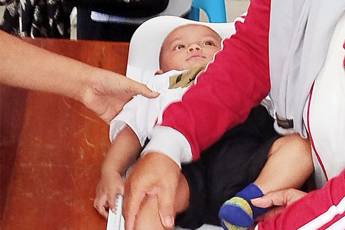 Bayi di bawah satu tahun sedang diperiksa di Posyandu Balai Desa Tirtomarto Kecamatan Ampelgading Kabupaten Malang