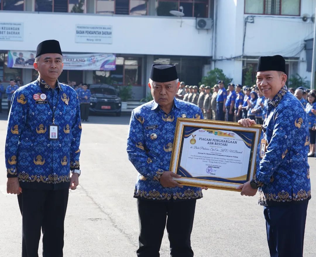 MEMBANGGAKAN: Plt Direktur Rumah Sakit Umum Daerah (RSUD) Kanjuruhan dr Bobi Prabowo SpEM KEC M Biomed (kanan) menerima penghargaan dari Bupati Malang H M. Sanusi hari ini (17/9).