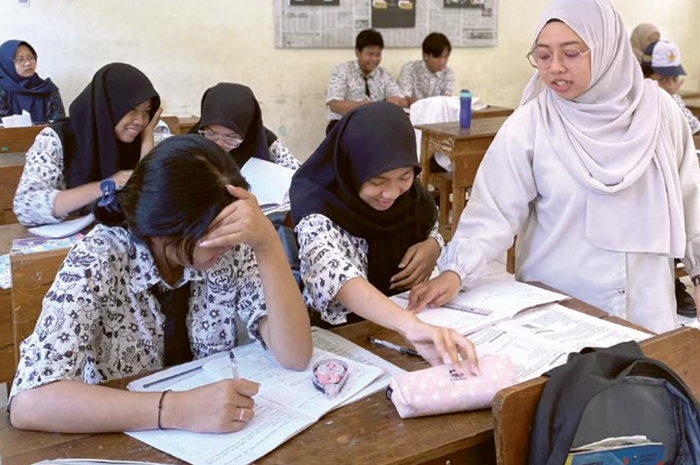 MENCERDASKAN SISWA: Guru SMP Sriwedari memberikan penjelasan materi pelajaran kepada siswa.