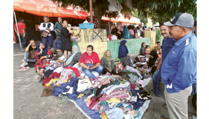 MENANTI KEPASTIAN: Beberapa pedagang terdampak kebakaran Pasar Baru Barat Comboran menggelar dagangan pakaian bekas di depan pasar kemarin (18/9).