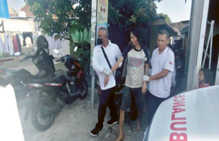 SUPAYA AMAN: Petugas membawa seorang penderita gangguan jiwa untuk mendapat perawatan.