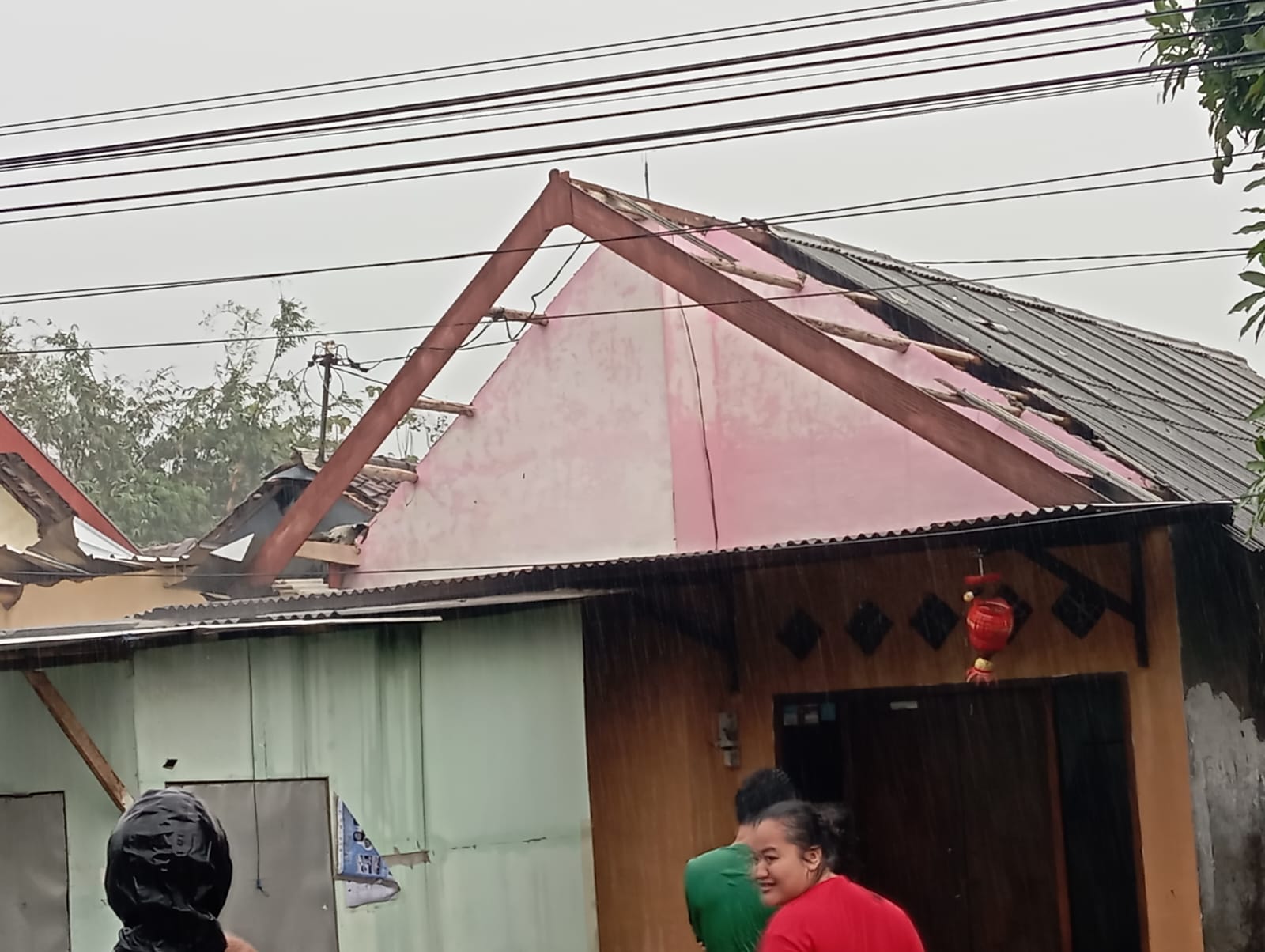 BENCANA: Warga Desa Kendalpayak, Kecamatan Pakisaji menyaksikan atap rumahnya yang rusak akibat diterjang angin kencang kemarin.