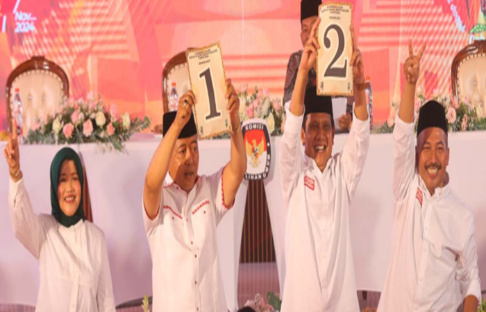 YAKIN MENANG: Calon Bupati Malang Sanusi mengangkat angka satu, sementara Gunawan yang menjadi lawannya mengangkat angka dua setelah pengundian nomor urut kemarin (23/9).