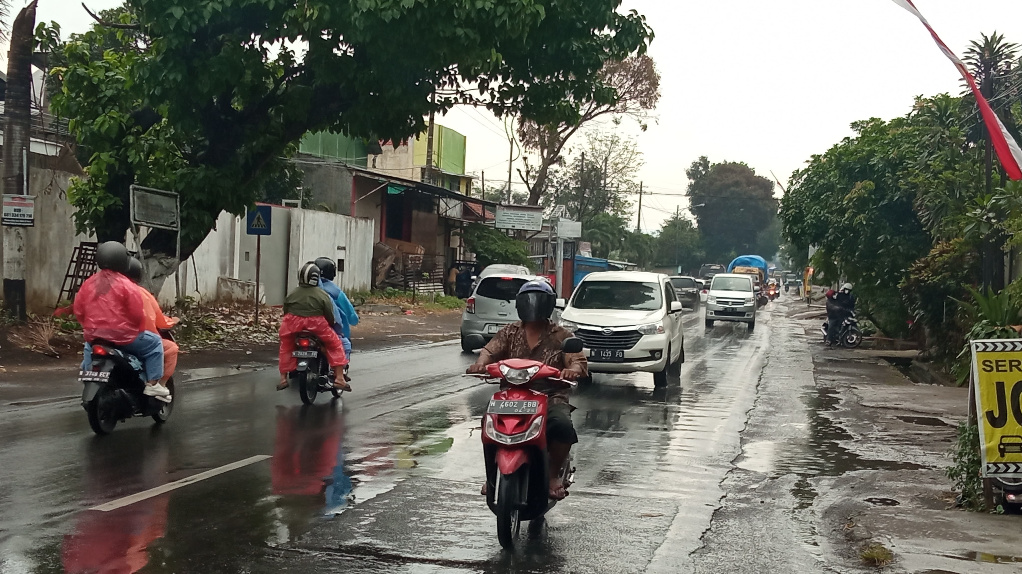 CUACA TAK MENENTU: Pengendara melintasi Jalan Raya Kendalpayak, Kecamatan Pakisaji, Kabupaten Malang di tengah guyuran hujan kemarin (27/9)
