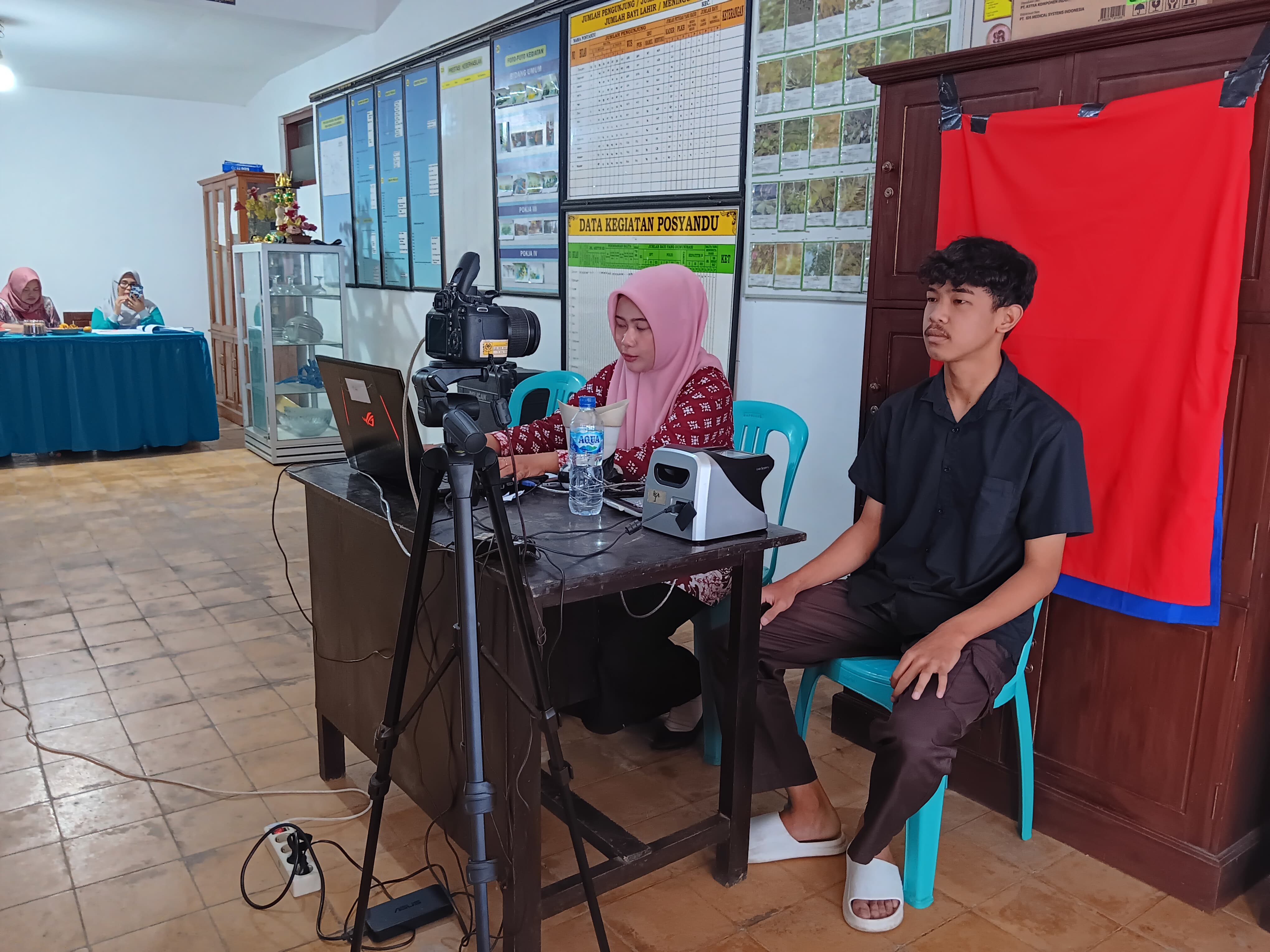 ADMINDUK: Petugas Dispendukcapil Kabupaten Malang membantu masyarakat yang datang untuk mengurus IKD di kantor Desa Ardimulyo, Singosari.