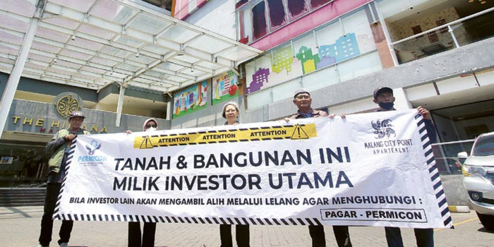 BERTAHAN: Sejumlah user Malang City point membentangkan poster penolakan lelang di depan gedung MCP kemarin (2/10).