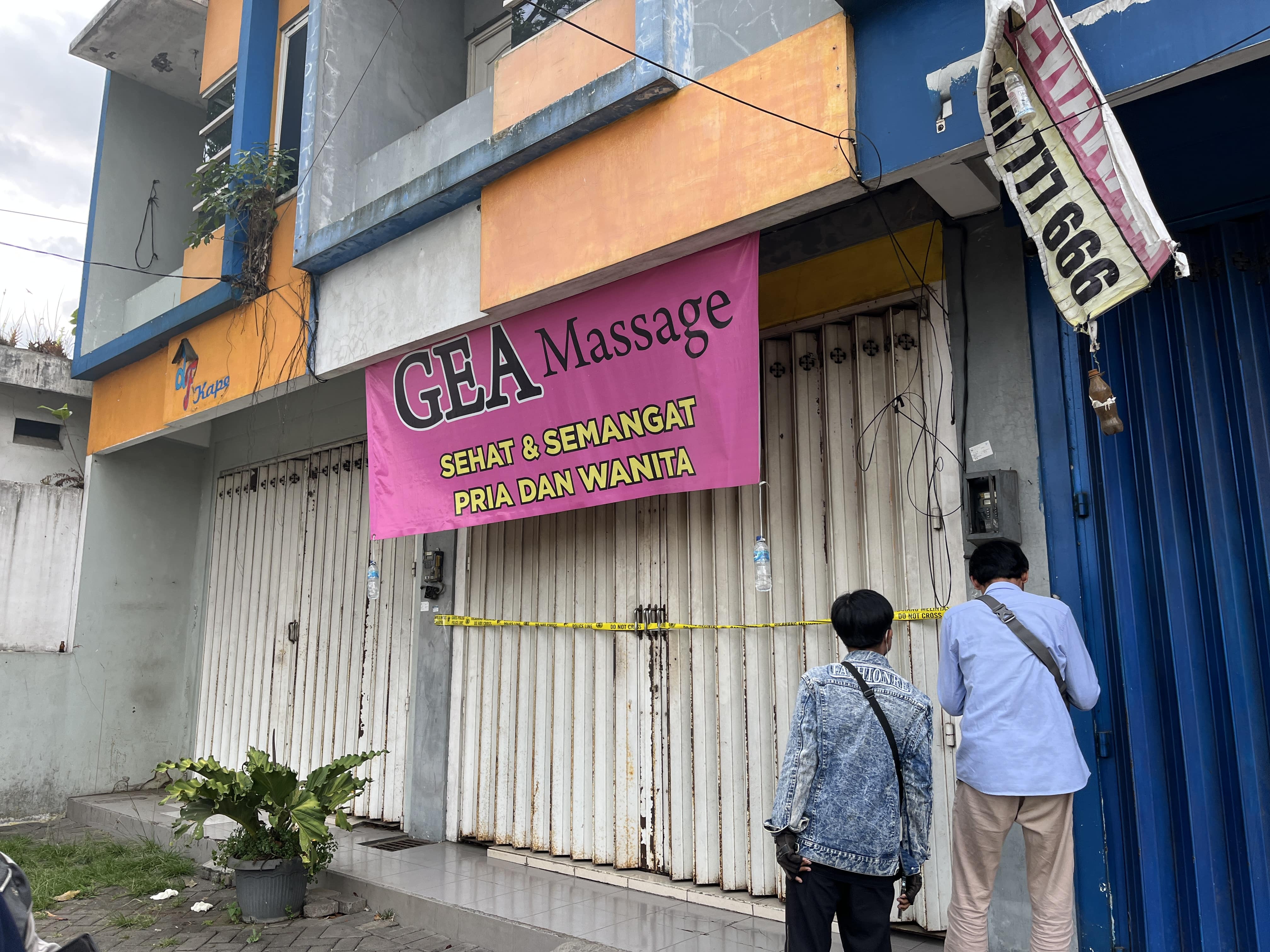 PENGGEREBEKAN: Dua orang warga mengamati police line yang membentang di pintu Panti Pijat Gea Massage, Jalan Nasional 23 Dusun Bendo, Desa Karangpandang, Kecamatan Pakisaji kemarin (4/10).