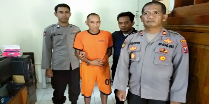 Tersangka PN (68) diapit petugas Polsek Sumbermanjing Wetan Polres Malang