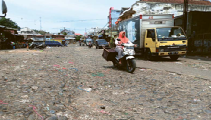 JALAN RUSAK: Para pengendara melintasi jalan bebatuan di sekitar  Pasar dampit, Jumat lalu (4/10). Banyak warga yang merasa tidak  nyaman dengan kondisi jalan tersebut.