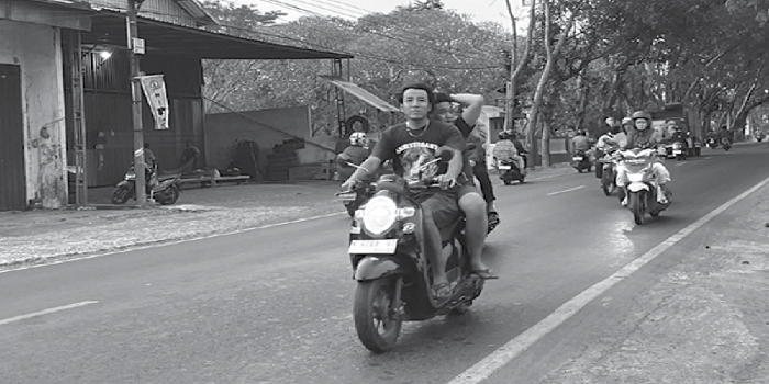 HARUS DITERTIBKAN: Seorang pengendara di Jalan Raya tidak memakai helm. Mereka akan ditilang jika terjaring Razia.