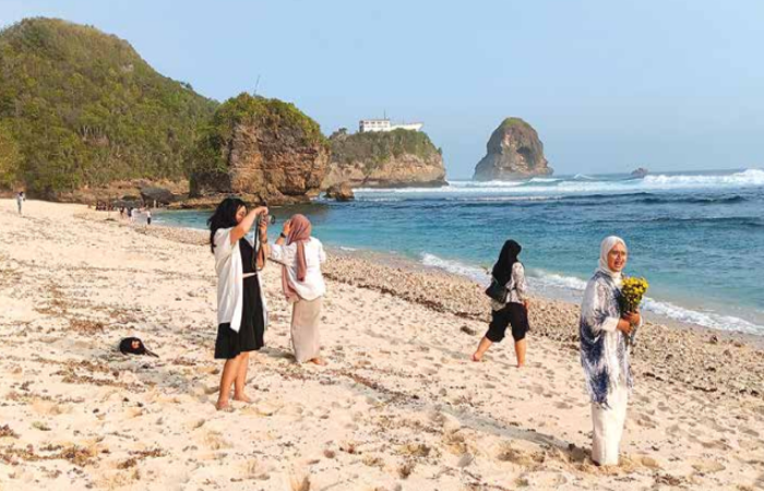 DESTINASI: Wisatawan bersantai sambil menikmati keindahan Pantai Watu Leter di Dusun Rowotrate, Desa Sitiarjo, Kecamatan Sumbermanjing Wetan, Sabtu lalu (12/10).