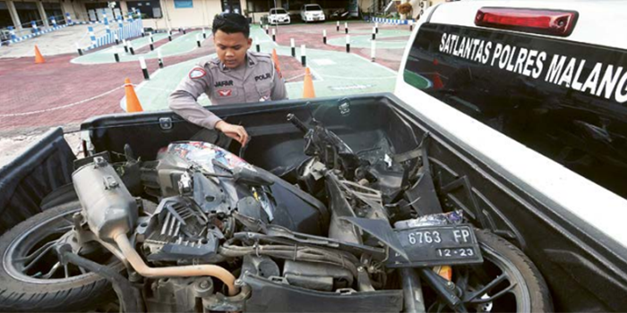 RUSAK: Polisi memeriksa kondisi Honda Vario dengan nopol N 6763 FP di Unit Laka Singosari Polres Malang kemarin (13/10).