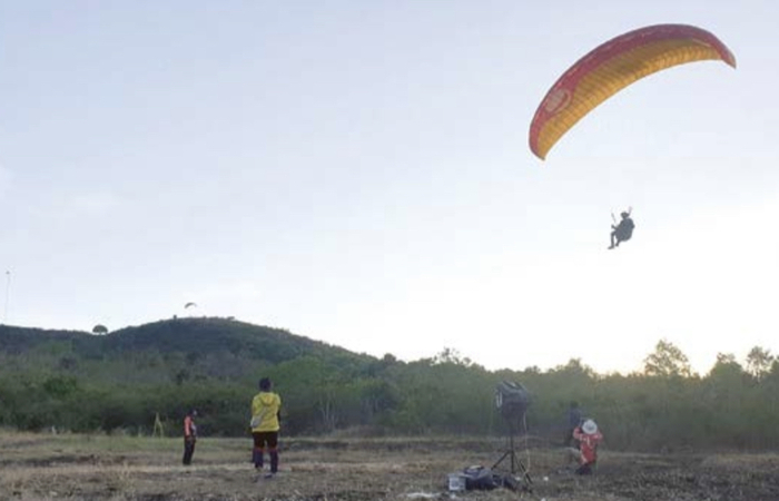 KEKUATAN TEREDUKSI: Atlet Paralayang Kota Batu berusaha mendarat dalam sesi latihan di Gunung Banyak, Batu, pekan lalu.
