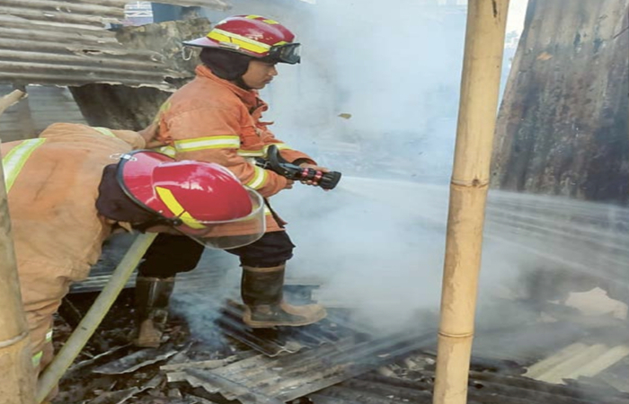 DIDUGA KARENA KORSLETING: Petugas damkar kota Malang memadamkan api yang menghanguskan kios BBM di Jalan Ki Ageng Gribig kemarin.