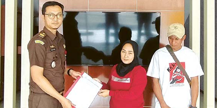 DAMAI: Yeni Ernawati (tengah) menerima surat keterangan penghentian perkara dari Kejaksaan Negeri (Kejari) Kabupaten Malang.