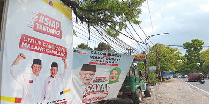 SOSIALISASI: Baliho dua pasangan calon (paslon) berjejer di tepi Jalan Raya Kebonagung, Kabupaten Malang, Jumat (18/10). INDAH MEI YUNITA/RADAR KANJURUHAN