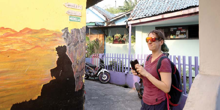 SPOT FAVORIT: Wisatawan mancanegara berjalan di sudut Kampung Tridi kemarin siang. Kunjungan wisatawan tercatat masih stabil. DARMONO/RADAR MALANG