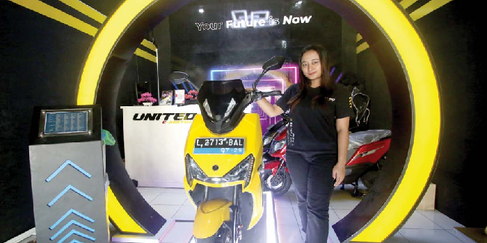PRODUK ANDALAN: Seorang SPG memamerkan salah satu produk motor listrik yang dijual kemarin. SATRIA CAHYONO/RADAR MALANG