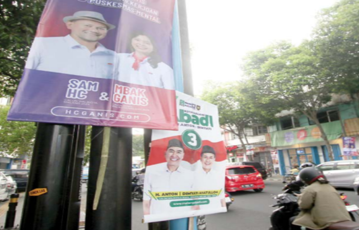 MELANGGAR ATURAN: APK milik dua paslon kompak terpasang di tiang listrik.