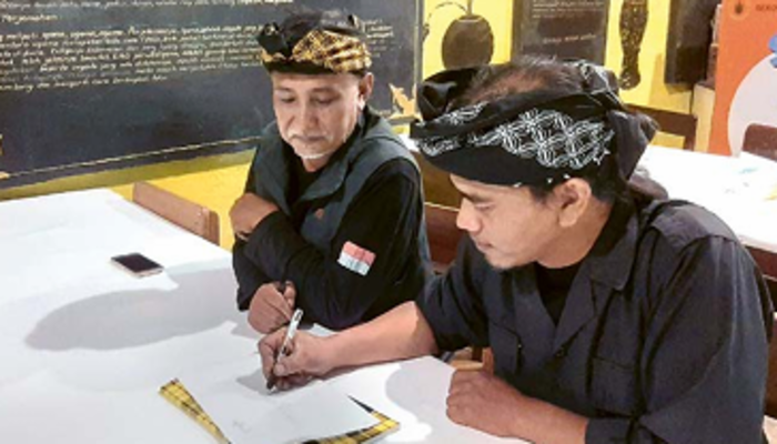 PEDULI BUDAYA: Kholiq Nuriadi (kiri) dan salah seorang temannya yang juga  pegiat budaya menyiapkan materi untuk mengajar menulis aksara  Jawa kuno di Sekolah Budaya Tunggulwulung.