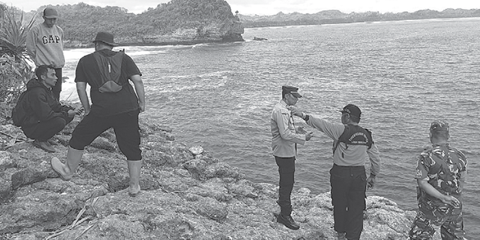 MENYISIR PANTAI: Tim gabungan dari memantau perairan dari tebing tepi pantai kemarin (20/10). Mereka menyisir area hilangnya korban.