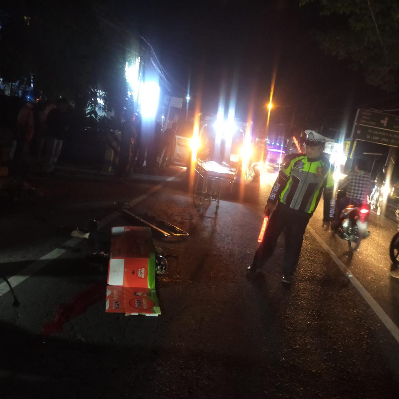LAKA LANTAS: Jenazah korban masih tergeletak di ruas jalan saat polisi mengatur arus lalu lintas pada Selasa malam (22/10)