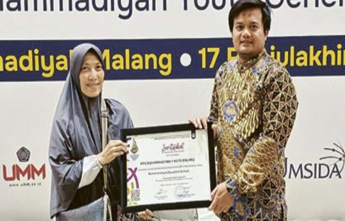EXCELLENT SCHOOL: Asessor Muhammadiyah Future School 2024Ahmad Nurefendi Fradana MPd (kanan) menyerahkan sertifikat penghargaan kepada Kepala MTs Muhammadiyah 1 Malang Truli Maulida W. MA.