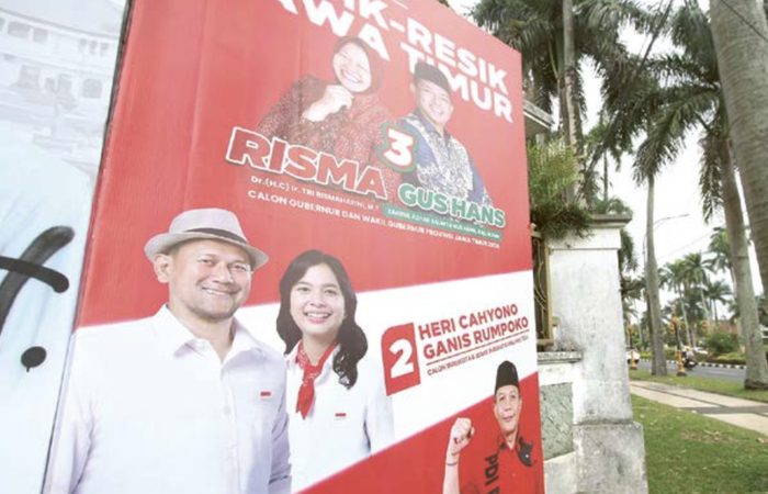 TERMASUK PEJABAT PUBLIK: Banner salah satu paslon di Jalan ijen turut menampilkan foto dari salah satu anggota DPRD Kota Malang.