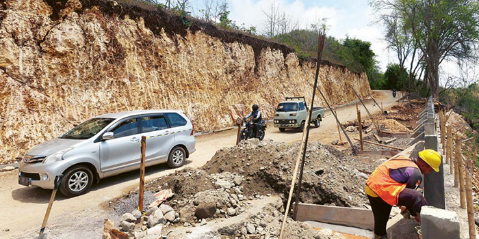 PELAN-PELAN: Sejumlah kendaraan melewati Jalan Rajekwesi di Desa Tumpakrejo, Kecamatan Kalipare, Kabupaten Malang. Jalan itu sempat ditutup sejak April lalu akibat longsor.