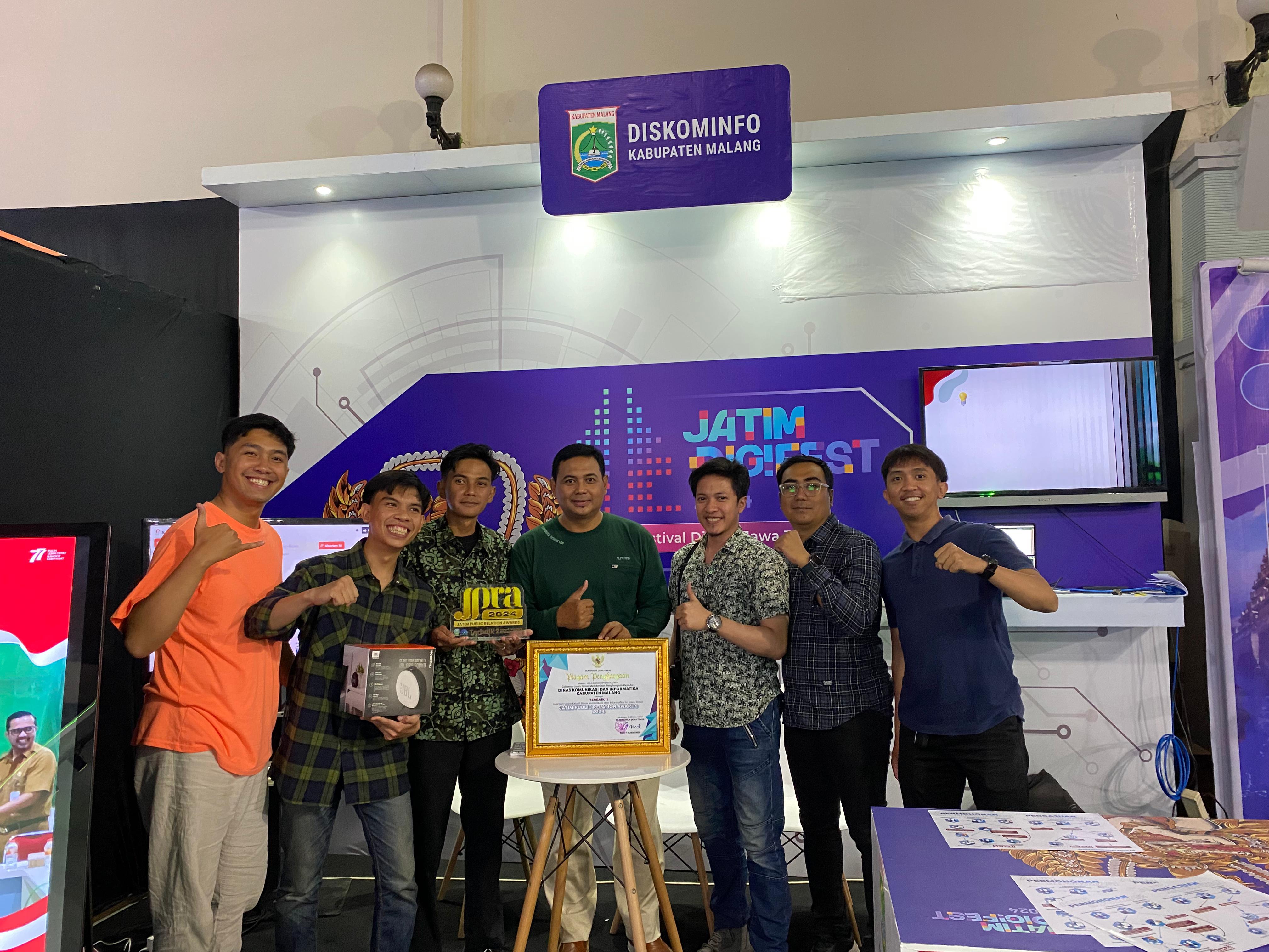 BERPRESTASI: Kepala Bidang Komunikasi Diskominfo Kabupaten Malang Iwan Heri Kristanto (tengah) bersama tim setelah meraih penghargaan di ajang Jatim Digital Festival 2024 di GOR Rangga Jaya Anoraga