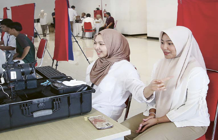 LANGSUNG JADI: Petugas Dispendukcapil Kota Malang mengarahkan warga yang melakukan perekaman e-KTp di MCC kemarin (27/10).
