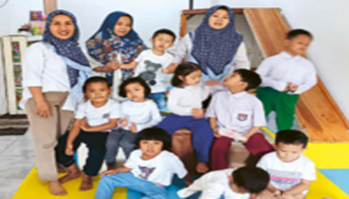 BERNIAT MEMBANTU: Noviana (kiri) berfoto bersama dua guru dan siswa-siswinya, Senin lalu (28/10).