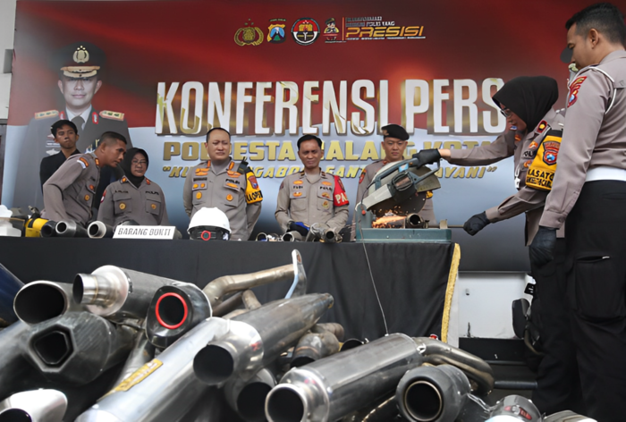 MENINGKAT: Personel Polresta Malang Kota memotong knalpot brong yang disita selama Operasi Zebra Semeru 2024, kemarin.