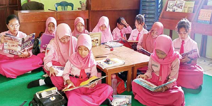BUDAYA LITERASI : Seluruh siswa SDN Percobaan 2 Malang dibiasakan berkunjung ke perpustakaan sekolah dengan membaca buku bersama.