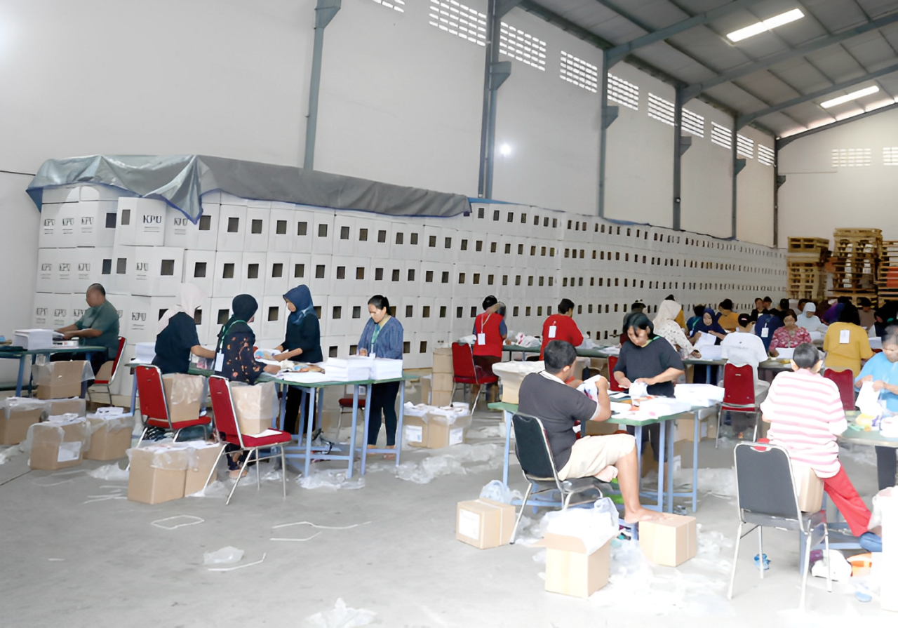 HARI PERTAMA: Puluhan petugas lipat surat suara bekerja di Gudang Logistik KPU Jalan Peltu Sujono Nomor 9A, Sukun, kemarin (1/11).