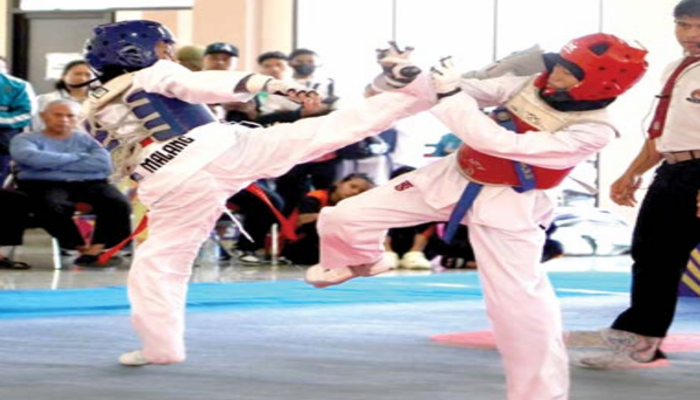 AWAL BAGUS: Atlet Taekwondo Kota Malang (kiri) mengarahkan tendangan ke arah lawannya dalam laga Popda Jatim kemarin.