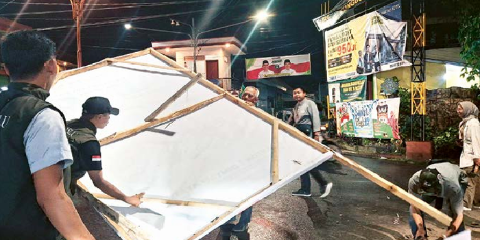 SUDAH DIBERI PERINGATAN: Salah satu alat peraga kampanye (ApK) di Simpang Akordion ditertibkan karena melanggar aturan, Selasa malam (5/11). NABILA AMELIA/ RADAR MALANG