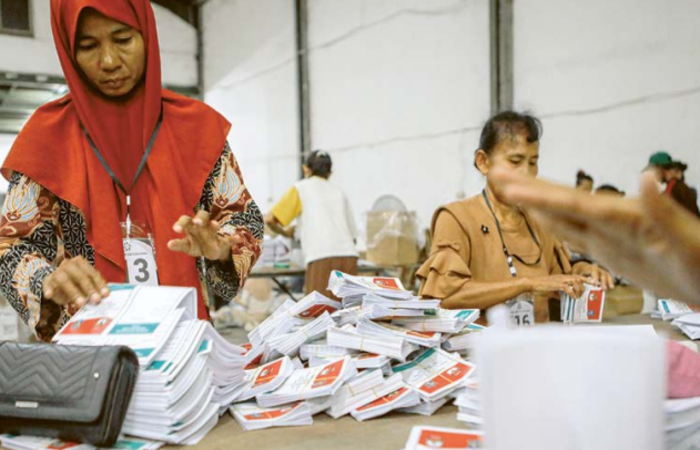TERUS DIKEBUT: Petugas melipat surat suara pilwali Surabaya di gudang logistik KPU kemarin siang.
