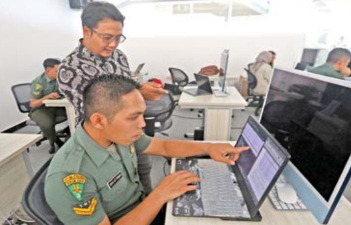 KEAMANAN NASIONAL: Vipkas Al Hadid Firdaus, Senior Cybersecurity Consultant PT Digital Solusi Group (baju batik) memberi arahan kepada salah satu anggota TNI, kemarin.