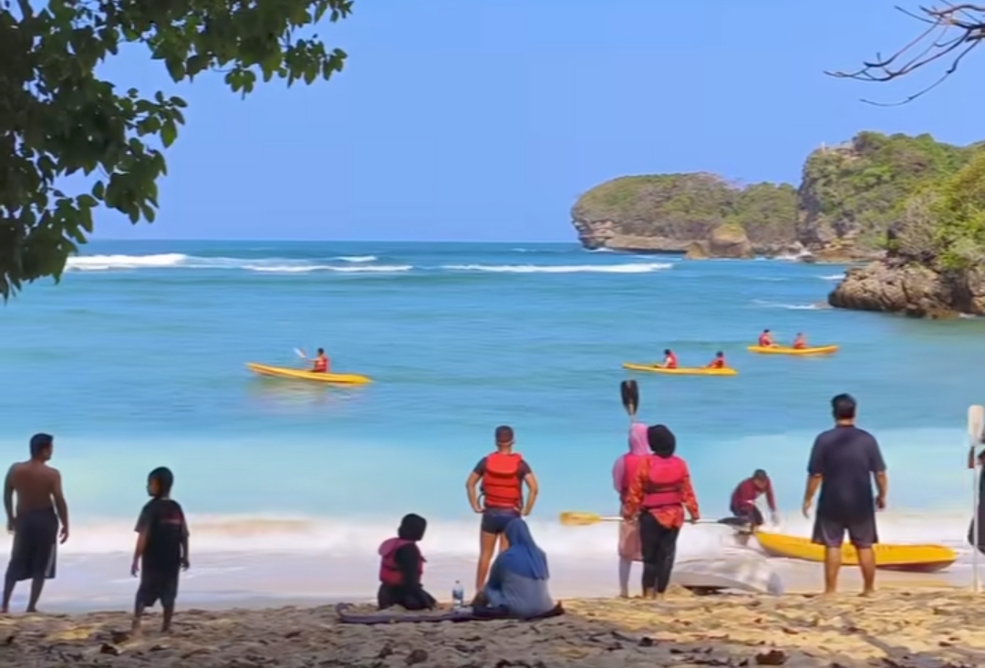 Wisatawan bermain kano di pantai tiga warna Sumbermanjing Wetan Malang selatan