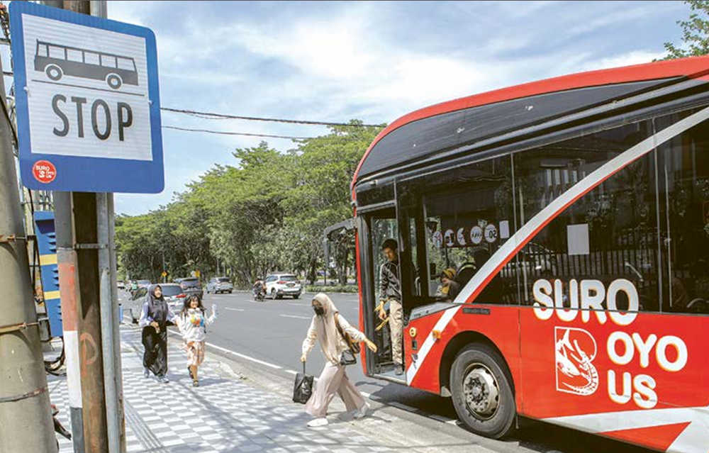 TRANSPORTASI PUBLIK: Seorang penumpang turun dari Suroboyo Bus di halte Jalan Ahmad Yani kemarin siang. DIPTA WAHYU/JAWA POS