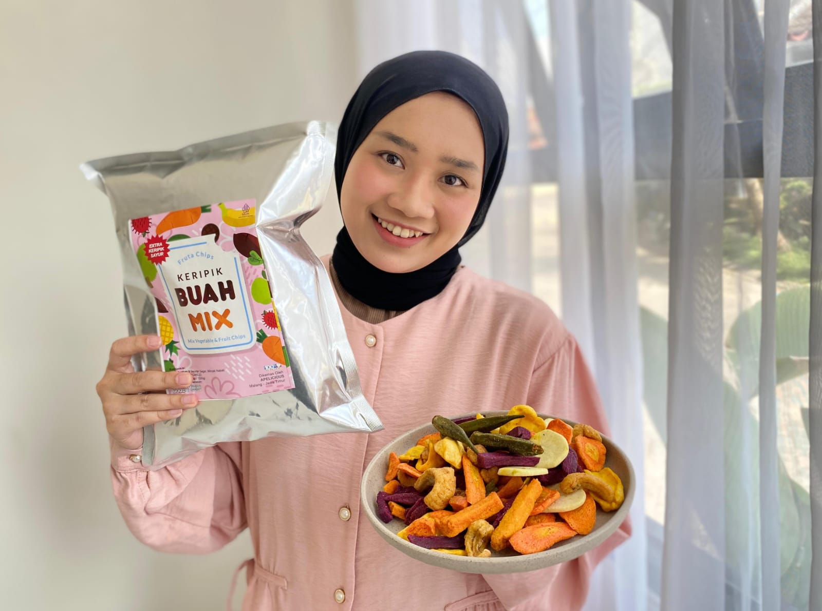DIBANTU 40 KARYAWAN: Noor Lisa Amalia menunjukkan contoh produk keripik buah dan sayurnya di rumah packing Apelicious di Perumahan Dinoyo Royal Park, Kecamatan Lowokwaru, kemarin (19/11).