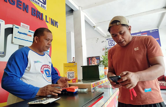 Budiono sedang melayani nasabah yang bertransaksi lewat BRILink Nikmat Cell Desa Lebakharjo, Kecamatan Ampelgading Kabupaten Malang