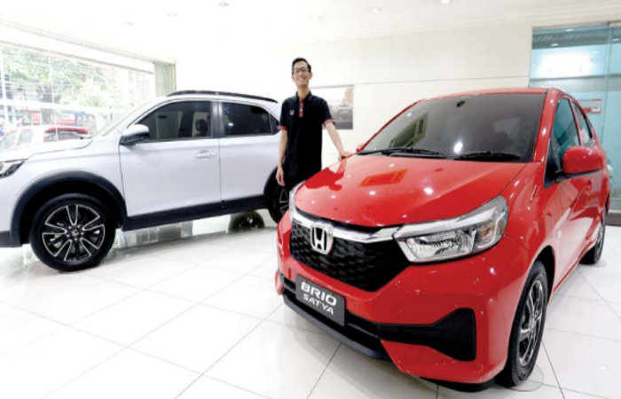 PENJUALAN MENINGKAT: Seorang sales menunjukkan dua varian mobil baru yang paling banyak dicari konsumen.