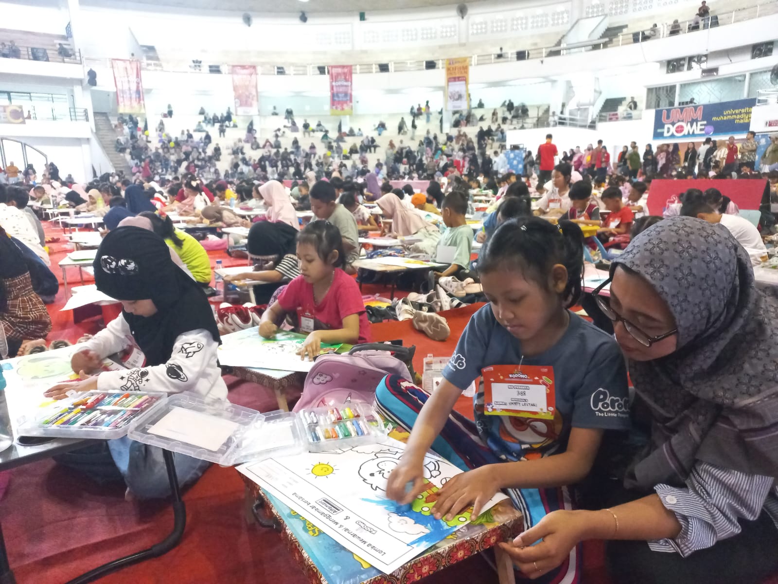 BERKEBUTUHAN KHUSUS: Vanni Lestari Wijoyo siswi SDN 1 Jatimulyo, Lowokwaru Kota Malang didampingi ibunya yang bernama Anita Yulia saat mengikuti lomba mewarna di UMM Dome, Minggu (24/11).