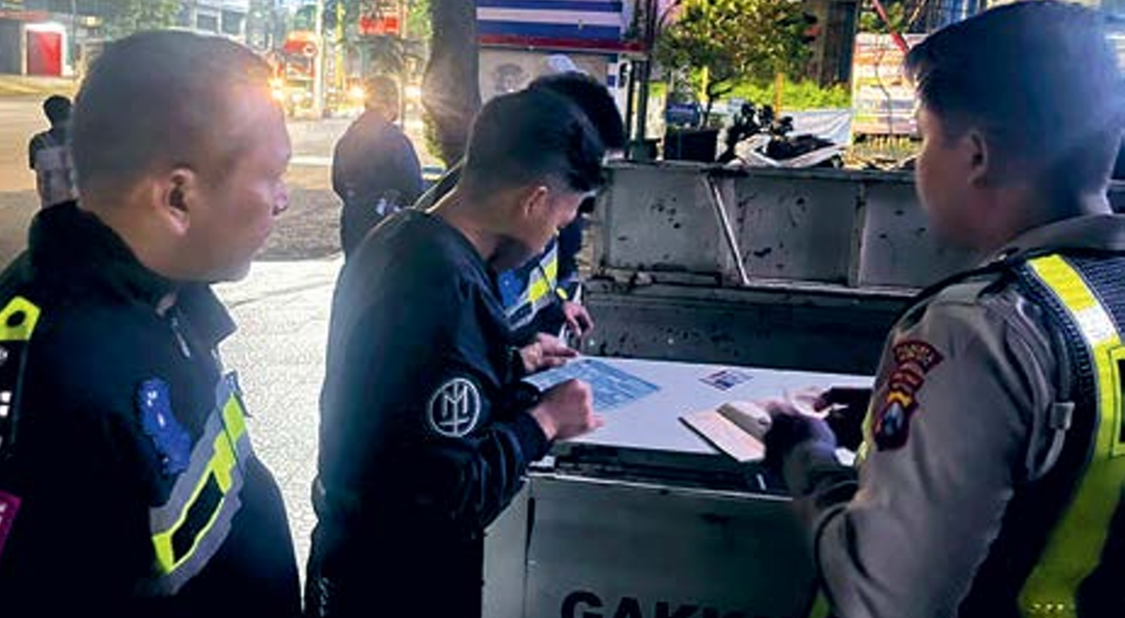 RAZIA RUTIN: Petugas langsung memberikan surat tilang terhadap pengendara yang membawa motor dengan knalpot brong, dini hari kemarin. SATLANTAS POLRESTA MALANG KOTA FOR RADAR MALANG